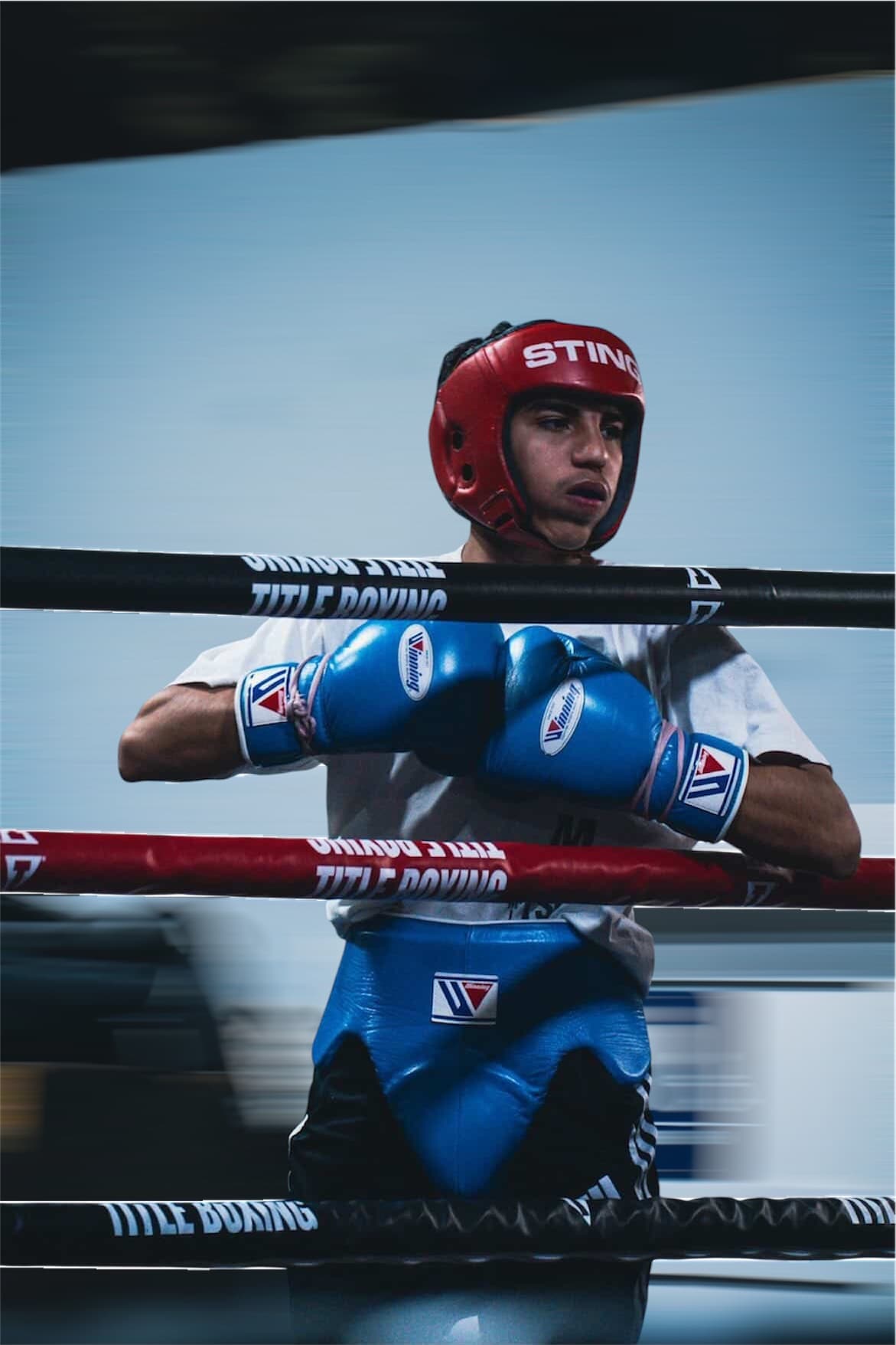 A fighter in the ring with gloves up, behind the ropes